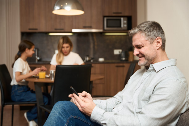 快乐的男人和他的家人早上在酒店房间里图片下载