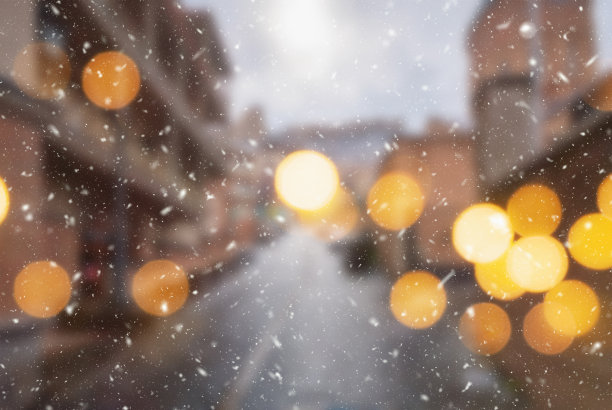 美丽的冬季模糊的第比利斯城市背景与飘落的雪和散景灯图片下载