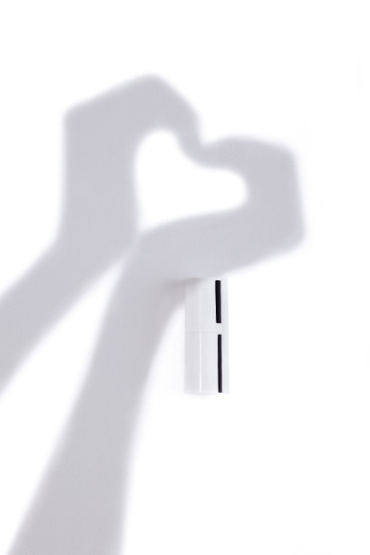 化妆品的白色试管模型和墙上的影子制作的手。图片下载