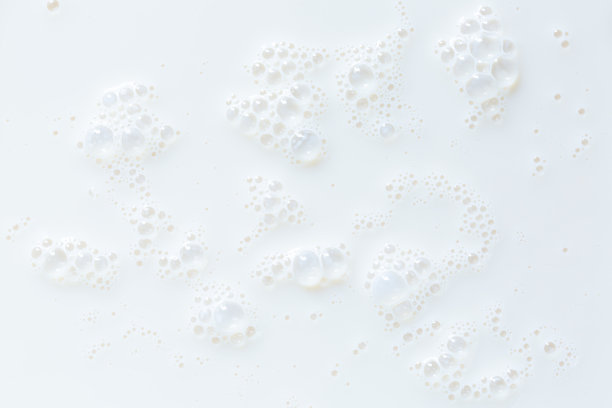 宏观牛奶背景，白色的牛奶表面和气泡和涟漪从鸟瞰图片下载