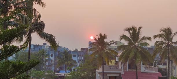 太阳落在建筑物顶部的地平线上图片下载
