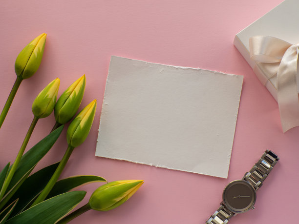 女性腕表粉红色的背景与郁金香花和复制空间图片下载
