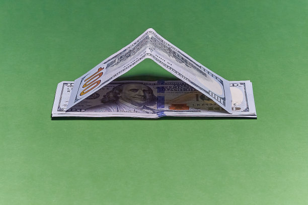绿布上的美元房子。按揭、房贷、储蓄买房、买房。图片下载