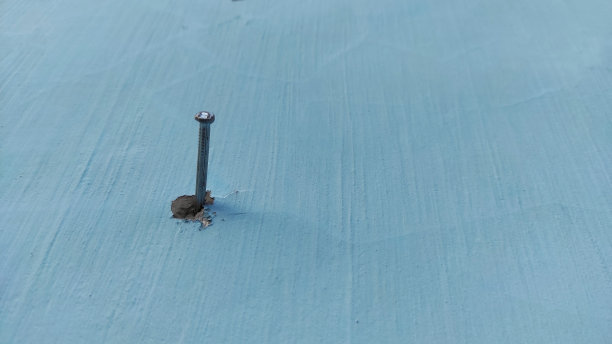 铁钉钉在蓝色的墙上图片下载