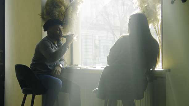 夫妻俩靠窗而坐，边聊天边喝酒图片下载