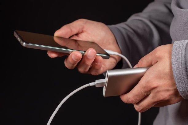 男人手里拿着手机和充电器，充电宝和智能手机正在连接，充电图片下载