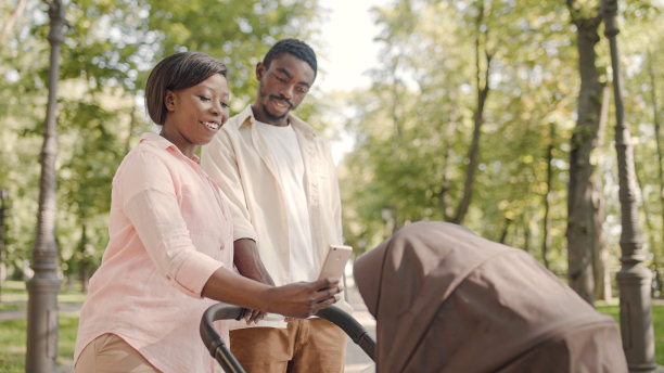 可爱的非裔美国父母在婴儿车里给他们刚出生的孩子拍照图片下载