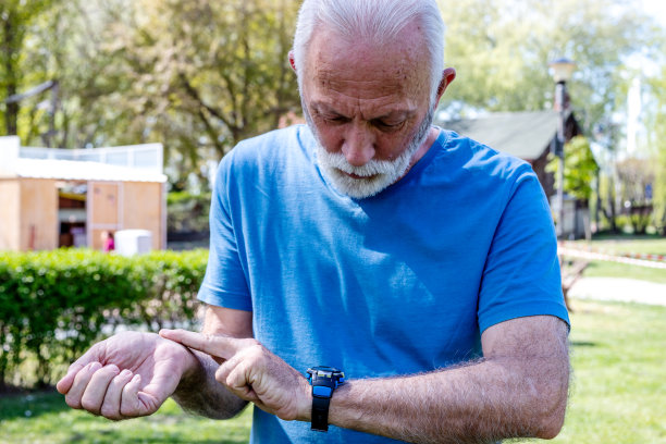 一个老人查看手表的特写。图片下载