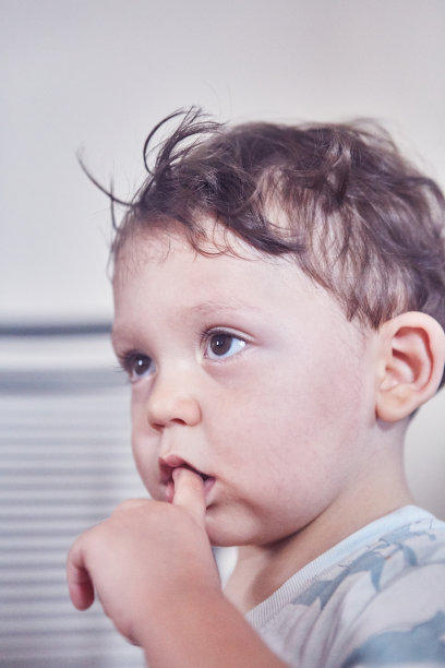 一个嘴巴含着手指的小孩的大头照图片下载