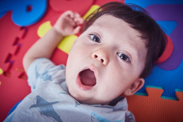 蹒跚学步的孩子躺在儿童游戏垫上图片下载