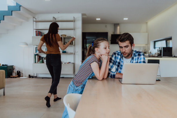 父亲和女儿在现代的房子里，在假期和家人一起在笔记本电脑上聊天。现代家庭的生活图片下载