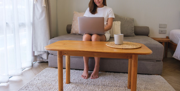 一个年轻女子在家里用笔记本电脑工作的特写图片下载