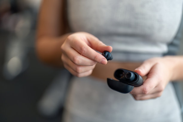 女人的手拿着黑色耳机的特写照片图片下载