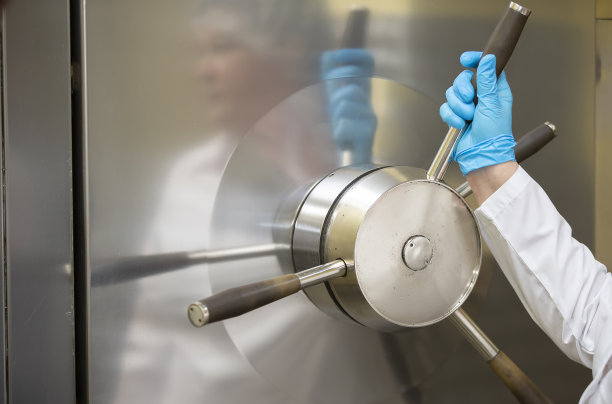 在制药或医疗设备制造厂，工人的手在转动阀门。图片下载