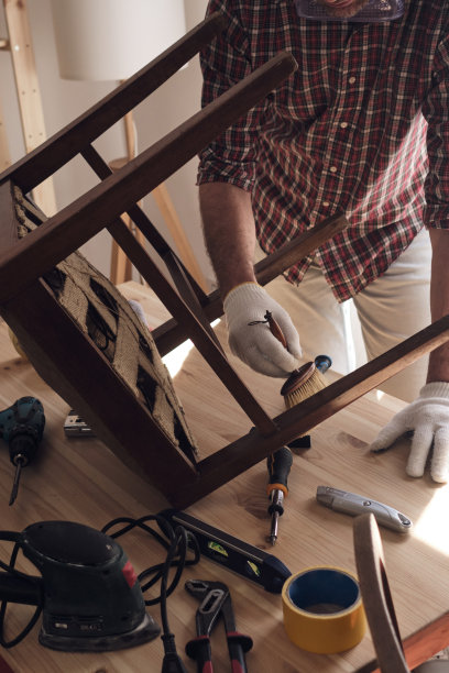 一名男子在一个小型家庭作坊里修理和修复家具。图片下载