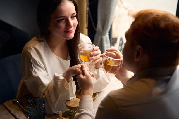 年轻人手里拿着杯子，手里拿着饮料图片下载