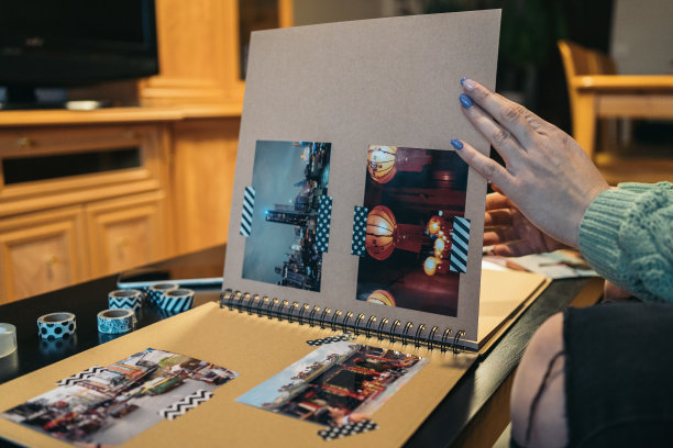一位无法辨认的中年妇女的手在翻动着她手工制作的牛皮纸旅行相册。图片下载