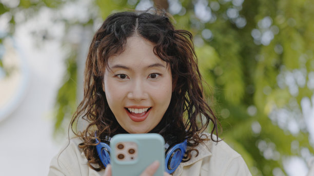 年轻的亚洲女性用触屏智能手机投资网上股票。图片下载