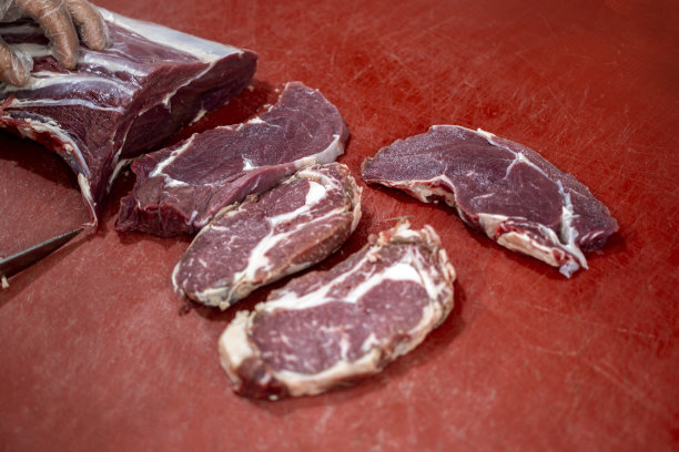 屠夫正在切最上面的圆牛排图片下载