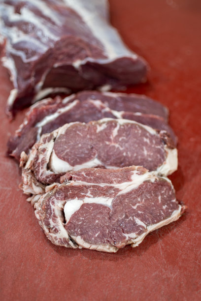 屠夫正在切最上面的圆牛排图片下载