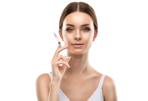 给穿黄衬衫的美女脸上打抗皱针。美容院的女性审美美容。图片下载