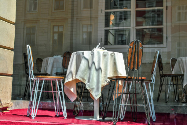 夏日户外咖啡馆露台上的空桌子和白色桌布和椅子图片下载