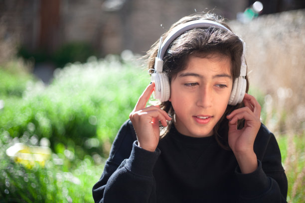 男孩戴着耳机听音频。图片下载