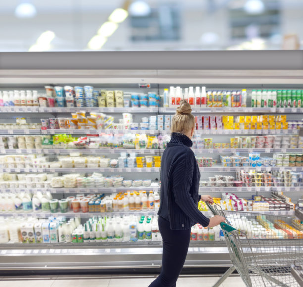 超市购物，一名妇女在超市挑选奶制品。图片下载