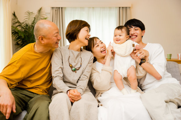 5个家庭的第三代父母和祖父母在客厅里看着一个0岁的婴儿图片下载