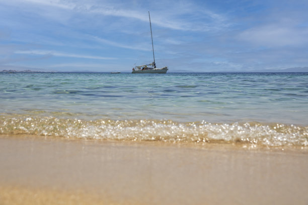 美丽的沙滩，清澈湛蓝的海水和帆船图片下载