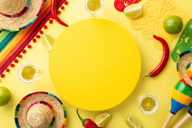 俯视图，宽边帽、雨披、沙球、龙舌兰酒、酸橙、辣椒被摆放在阳光明媚的黄色背景上，中间有一个空圈，非常适合做广告图片下载