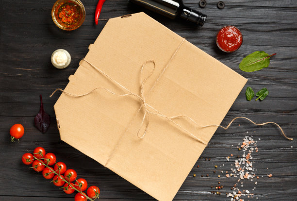 披萨在一个盒子在一个黑暗的木制背景顶视图空间的文字。图片下载