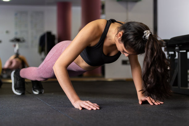 年轻女子在健身房做俯卧撑图片下载