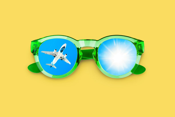 飞行飞机，太阳，蓝天上太阳镜反射，眼镜上黄色背景近距离拍摄，暑假设计，假期飞行，旅行社横幅，国际航空公司，旅游概念图片下载