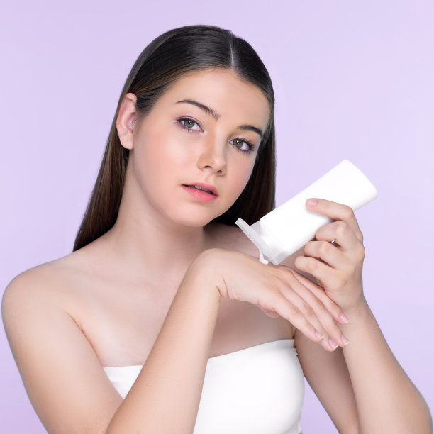 年轻迷人的自然美丽的女孩拿着乳液管图片下载