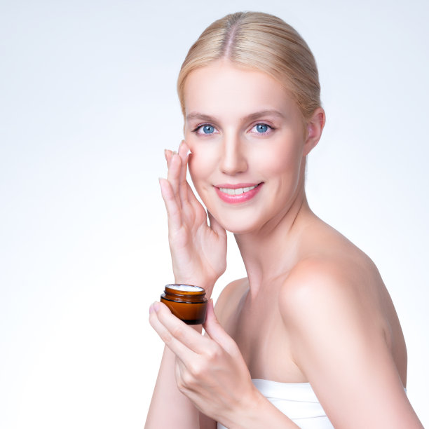 一位风度翩翩的女士在脸上涂抹保湿霜，以达到完美的滑雪效果图片下载