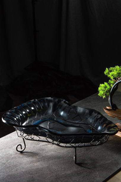 一个玻璃碗放在蓝色皮革背景前图片下载