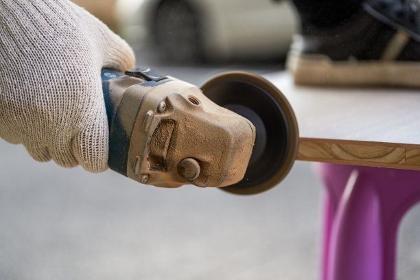 一个工人正在用砂盘切割机切割木头图片下载