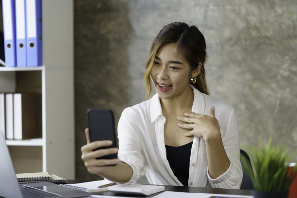 美丽的亚洲女商人在办公室与客户进行视频通话。图片下载