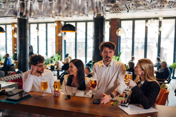 四个兴高采烈的企业家在酒吧里闲逛，喝着啤酒，聊着天图片下载