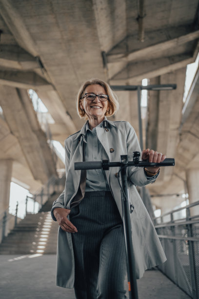 一位成熟的商业女性骑着电动滑板车上下班，以便更轻松地驾驭城市交通图片下载