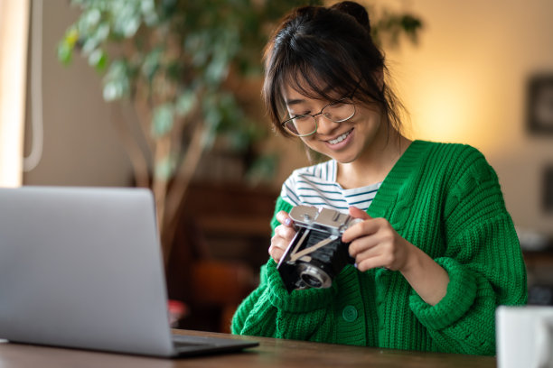 集中的亚洲年轻女孩在修理老式照相机图片下载