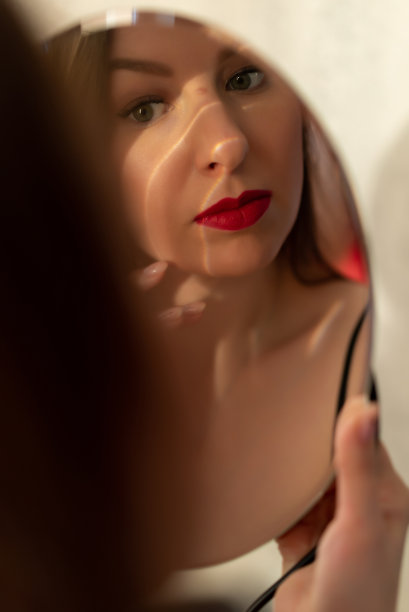 一个涂着红色口红、穿着黑色连衣裙的年轻女子。图片下载