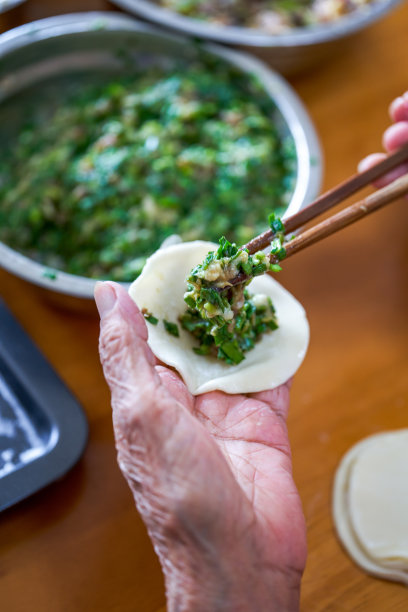 一个中国家庭的老人用手包饺子图片下载