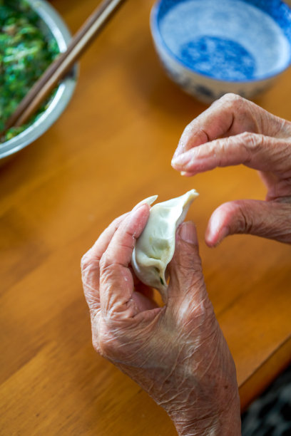 一个中国家庭的老人用手包饺子图片下载
