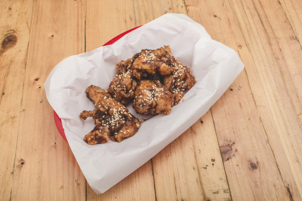 餐馆里的辣韩式鸡翅。放在用防油纸盖着的托盘上。图片下载