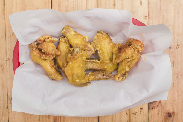 餐厅里的柠檬橙汁鸡翅。放在用防油纸盖着的托盘上。图片下载