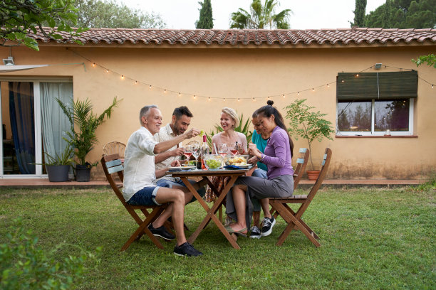 在一个夏日的下午，一群朋友围坐在花园里的一张桌子旁，分享一顿饭，共度美好时光。图片下载