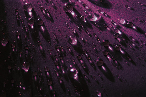 黑色背景上的圆水滴。光线穿过透明的水滴。从顶部看。漂亮的背部屏幕保护程序。抽象的背景。图片下载