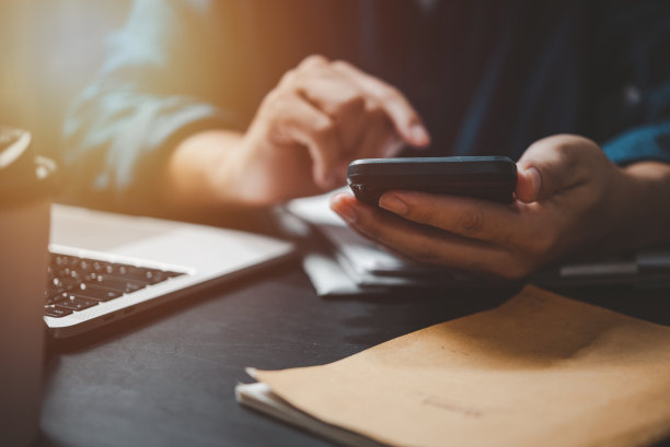 商务人士在笔记本电脑上工作，使用手机和社交媒体上网，搜索信息和求职概念。图片下载